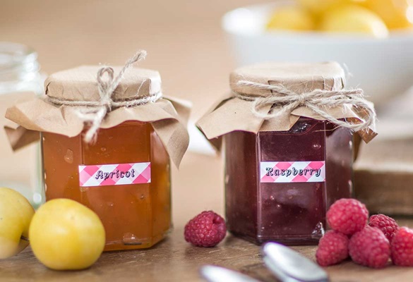Black on red gingham patterned labels identifying contents of home made jam in jars
