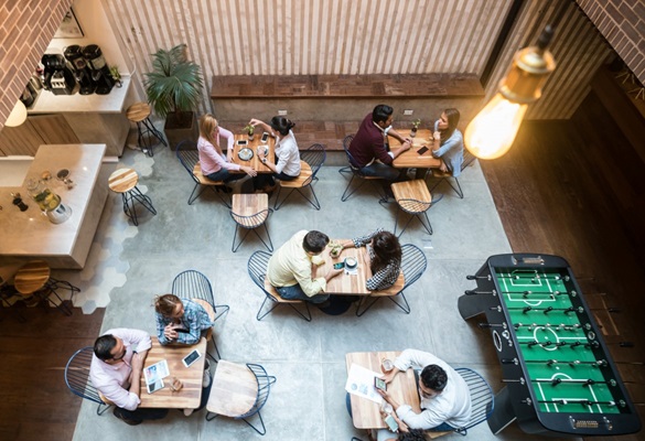 The workplace of the future is seen from a high angle looking down on a neat, minimalist office complete with hotdesks and a games table